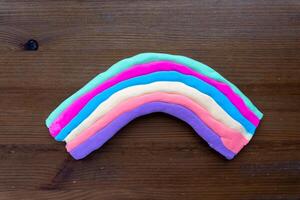 Kinder handgemacht Regenbogen mit thermoplastisch auf hölzern Oberfläche zum DIY Projekt foto