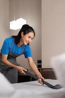 Reinigung Bedienung Mitarbeiter entfernen Schmutz von mit Fachmann Ausrüstung. weiblich Haushälterin Reinigung das Matratze auf das Bett mit Vakuum Reiniger foto