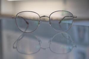 Brille auf Tisch, progressiv Linsen, Brille zum das Alten, Brille progressiv Linse, Brille progressiv Linse, Nahansicht von Brille auf Linsen prüfen, suchen durch Brille foto