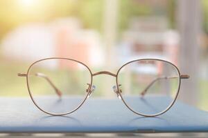 Brille auf Tisch, progressiv Linsen, Brille zum das Alten, Brille progressiv Linse, Brille progressiv Linse, Nahansicht von Brille auf Linsen prüfen, suchen durch Brille foto