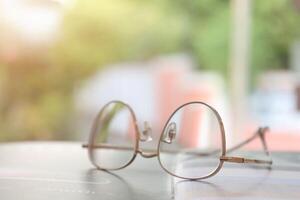 Brille auf Tisch, progressiv Linsen, Brille zum das Alten, Brille progressiv Linse, Brille progressiv Linse, Nahansicht von Brille auf Linsen prüfen, suchen durch Brille foto