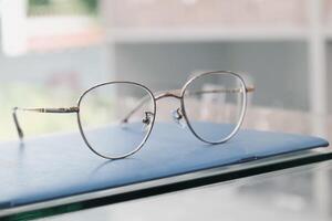 Brille auf Tisch, progressiv Linsen, Brille zum das Alten, Brille progressiv Linse, Brille progressiv Linse, Nahansicht von Brille auf Linsen prüfen, suchen durch Brille foto