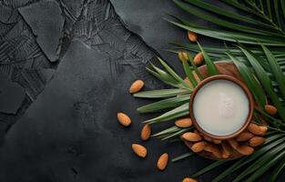 ai generiert Mandel Milch im hölzern Tasse und Mandeln mit Palme Blätter auf schwarz Beton Hintergrund foto