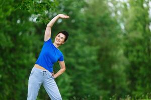 Senior Frau ausüben im Park. Alten weiblich tun Fitness Übungen draussen. Heide Leben Stil Konzept. Exemplar. foto