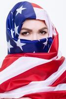 schön sirianische Frau tragen ein Hijab von das amerikanisch Flagge foto