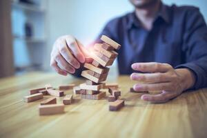 Geschäft Strategie Konzept mit Hände spielen ein hölzern Block Turm Spiel, symbolisieren Risiko und Stabilität. Planung Risiko Verwaltung foto