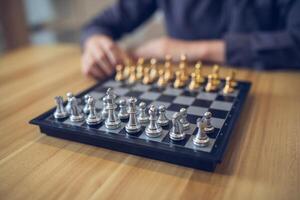 strategisch Betrachtung im Aktion mit ein Person Herstellung ein Schach Umzug, Fokus auf das golden und Silber Stücke. Geschäft Strategie Erfolg Konzept foto