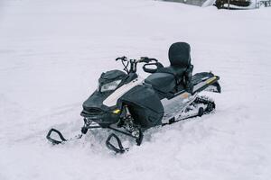 schwarz Schneemobil steht auf ein schneebedeckt Spur foto