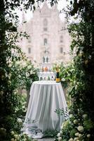 Stapel von Brille auf ein Tabelle Nächster zu ein Flasche von Champagner auf ein Balkon bedeckt mit Rosen mit Blick auf das Dom. Mailand, Italien foto