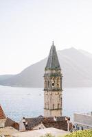 hoch uralt Glocke Turm von das Kirche von st. Nikolaus gegen das Hintergrund von das Meer. perest, Montenegro foto