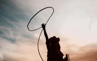 ziemlich Chinesisch Cowgirl werfen das Lasso im ein Pferd Koppel foto