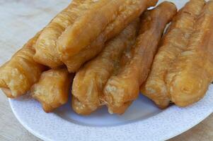 schließen oben von cakoi oder youtiao Kuchen auf Weiß Platte. asiatisch Essen Konzept foto