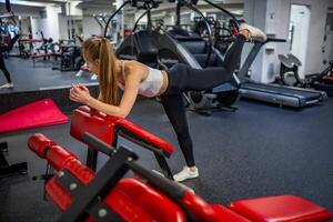 jung Frau funktioniert aus im das Fitnessstudio durchführen ein Übung. hoch Qualität Foto