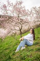 schön jung Frau im ein Blühen Rosa und Weiß Garten petrin im Prag, Frühling Zeit im Europa. hoch Qualität Foto