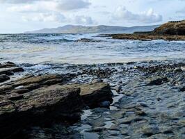 schön Küsten Landschaft Landschaft, wild atlantisch Weg, felsig Strand mit Berge im Hintergrund beim Killultan, Bezirk Donegal foto
