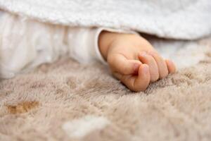 ein richtig Hand von Schlafen asiatisch Baby auf das Teppich foto