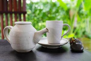 heißer Tee wurde in eine Teetasse gegossen, die im Café auf dem Tisch serviert wurde? foto