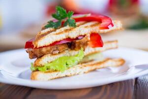 gebraten Toast mit Huhn, Salat, Grüns auf ein hölzern Tabelle foto