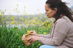 jung Frau sammelt medizinisch Heilung Kräuter im das Prärie im Berge. das Konzept von Kräuter- Medizin und Naturheilkunde foto