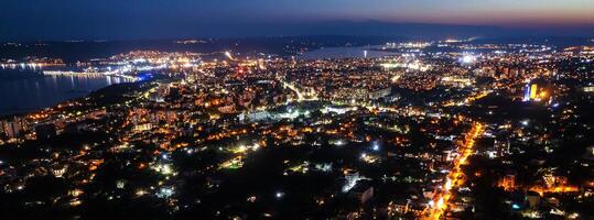 ein Panorama- Antenne Aussicht von das Stadt in der Nähe von das Meer beim Nacht. foto