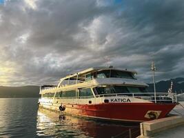 tivat, Montenegro - - 25 Dezember 2022. rot und Weiß Doppeldeck Vergnügen Yacht ist festgemacht in der Nähe von das Strand foto