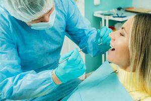ein Zahnarzt im ein schützend Maske sitzt Nächster zu ihm und Leckereien ein geduldig im das Dental Büro foto