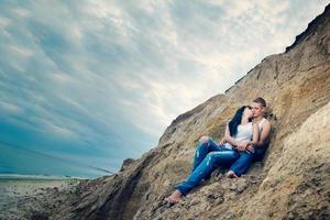 Typ und ein Mädchen in Jeans und weißen T-Shirts am Strand foto