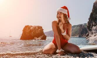 Frau Reise Meer. glücklich Tourist genießen nehmen Bild auf das Strand zum Erinnerungen. Frau Reisender im Santa Hut sieht aus beim Kamera auf das Meer Bucht, Teilen Reise Abenteuer Reise foto