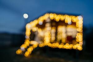 abstrakt defokussiert hell Weihnachten Beleuchtung auf hölzern Haus, Erstellen dekorativ Erleuchtung im Abend Szene foto