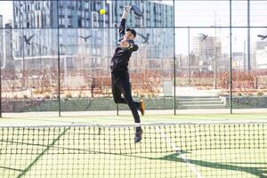 Mann spielen Paddel Tennis. Springen und Schießen das Ball. foto