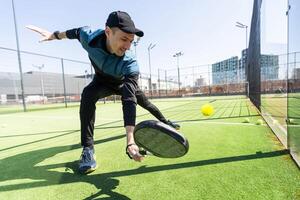 Mann spielen Paddel Tennis beim drinnen Tonhöhe foto