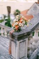 Braut- Strauß steht auf das Stein Geländer von ein uralt Balustrade im das Garten foto