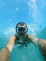 Schwimmer im Brille Tauchgänge unter das Wasser, erziehen spritzt foto