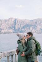 Mann und Frau fast Kuss in der Nähe von das Stein Balustrade Über das Meer foto