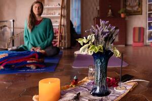 Meditation Altar mit Lavendel Blumen und Weihrauch, Hintergrund verschwommen mit ein jung Frau meditieren. foto