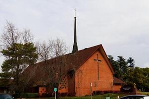 Messe Eichen, ca, 2013 - - rot Backstein Christian Kirche mit Bäume und bedeckt Himmel foto