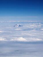 Schicht von Weiß Wolken mit Berg oben spähen durch foto