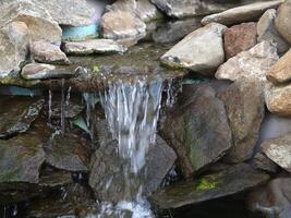 künstlich gemacht Felsen Wasserfall Brunnen Teich draußen Moos foto