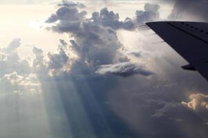 Sonnenlicht Streifen durch Wolken draußen Flugzeug Fenster foto