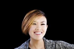 lächelnd Porträt attraktiv asiatisch amerikanisch Frau auf schwarz Hintergrund foto