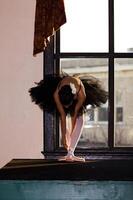 jung afrikanisch amerikanisch Frau im tanzen Outfit im Vorderseite von Fenster foto
