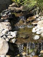 künstlich gemacht Felsen Wasserfall Brunnen Teich draußen Moos foto