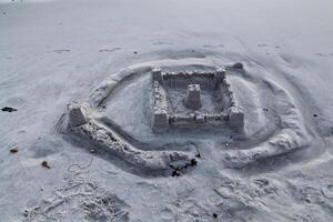 teilweise gewaschen Weg Sand Schloss auf Strand foto