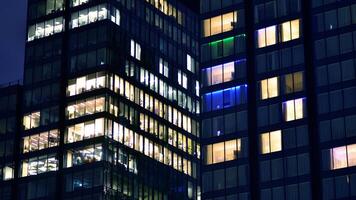 Büro Gebäude durch Nacht. Nacht architektonisch, Gebäude mit Glas Fassade. modern Gebäude im Geschäft Bezirk. Konzept von Wirtschaft, finanziell. foto