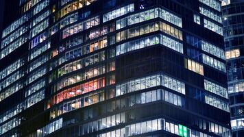 Büro Gebäude durch Nacht. Nacht architektonisch, Gebäude mit Glas Fassade. modern Gebäude im Geschäft Bezirk. Konzept von Wirtschaft, finanziell. foto