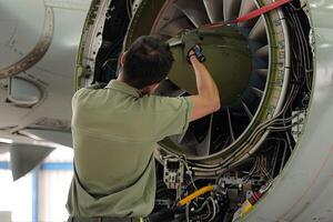 ai generiert Aussicht von das zurück von Flugzeug Instandhaltung Techniker Arbeiten auf Turbine foto