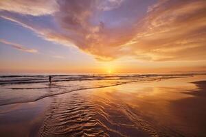 atlantisch Ozean Sonnenuntergang mit wogend Wellen beim fonte da telha Strand, Portugal foto