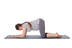 schwanger Frau tun Yoga Asana Balasana Kind Pose foto