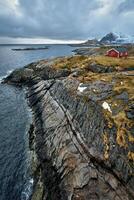 clif mit traditionell rot rorbu Haus auf Lofoten Inseln, Norwegen foto