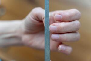 Frau Hände tun Maniküre Behandlung, Einreichung Nägel mit ein Nagel Datei foto